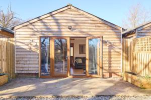 a large wooden shed with sliding glass doors at Host & Stay - Willow Barn in Aldington