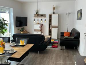 salon z 2 czarnymi krzesłami i stołem w obiekcie "Golden Delicious" Neubau Barrierefrei Carport Terrasse Netflix Free WIFI w mieście Meppen
