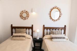 2 Betten in einem Schlafzimmer mit einem Wandspiegel in der Unterkunft Edificio Torre de Calpe in Calpe