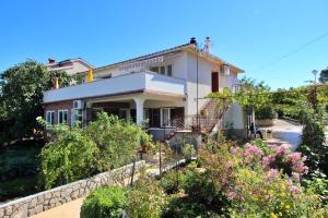 una casa con un jardín delante de ella en Apartments Dragica, en Šilo