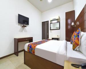 una habitación de hotel con una cama y un televisor en FabHotel Jaipur Casa, en Jaipur