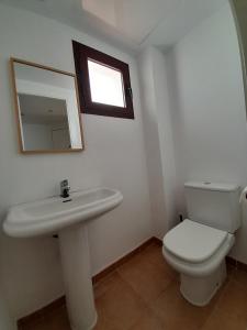 uma casa de banho com um WC, um lavatório e um espelho. em Valle Verde Alcaidesa em San Roque