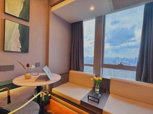Habitación con escritorio, mesa y ventana. en Guangzhou Xing Yi International Apartment Hotel - Vertical City Branch, en Guangzhou