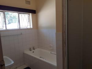Un baño con bañera y ventana. en Sweet home guesthouse, en Mthatha