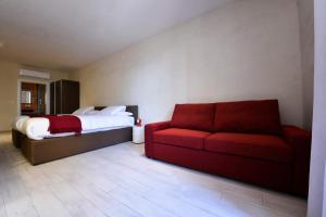 a bedroom with a bed and a red couch at Quaint Boutique Hotel Sannat in Sannat