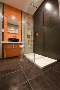 a bathroom with a glass shower and a sink at Quaint Boutique Hotel Sannat in Sannat