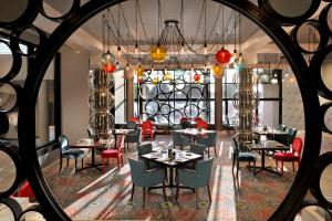 - une salle à manger avec des tables, des chaises et un miroir dans l'établissement InterContinental Abu Dhabi, an IHG Hotel, à Abu Dhabi