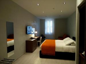 a hotel room with a bed and a desk with a computer at Quaint Boutique Hotel Sannat in Sannat