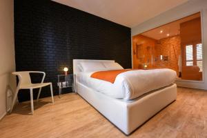 a bedroom with a white bed and a black wall at Quaint Boutique Hotel Sannat in Sannat