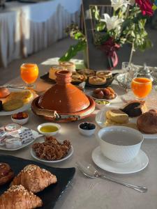 una mesa llena de comida y una tetera en ella en Eventi Club by cité des sports adarissa, en Fez