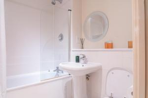 a white bathroom with a sink and a shower at Stay in our Stylish Flat! & Parking & secure building & sleeps up to 4 in Birmingham