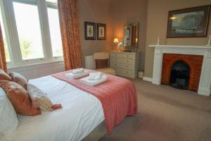a bedroom with a bed and a fireplace with two towels at Geltsdale Wing, Wetheral in Wetheral