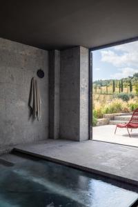 una camera con piscina, sedia e finestra di PODERE 1384 a Castellina in Chianti