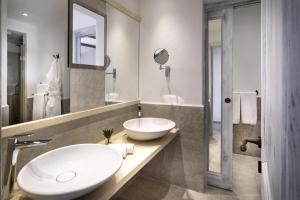 ein Badezimmer mit einem weißen Waschbecken und einem Spiegel in der Unterkunft Park Hotel & Spa Cala Di Lepre in Palau