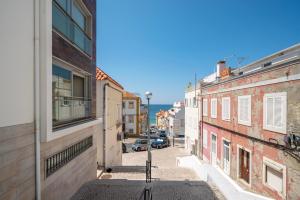 a view of an alley between two buildings at Boho Chic Beach Duplex in Sesimbra