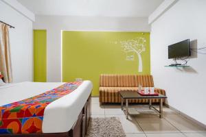 a bedroom with a bed and a couch and a tv at Hotel JK Lions - Koradi, Nagpur in Nagpur