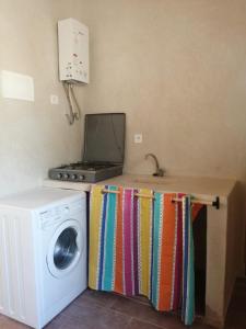 een keuken met een fornuis en een wasmachine bij Jolie Appartement in Agadir