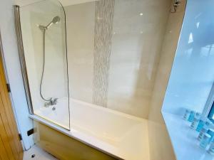 a shower in a bathroom with a glass wall at Just £45pppn! Prime Comfort for Contractors with Spacious Parking, Plush Beds, Top-notch Amenities, Flexible Stays & Lightning-Fast Internet in Woking