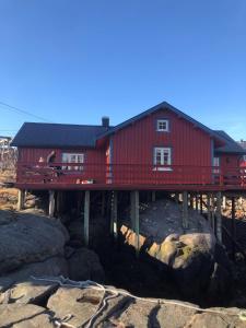 una casa roja sentada en un puente de madera en Elisabeth-Bua, en Moskenes
