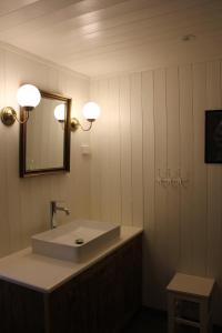 a bathroom with a white sink and a mirror at Elisabeth-Bua in Moskenes