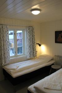 a bedroom with two beds and a window at Elisabeth-Bua in Moskenes