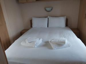 a white bed with two towels on it at A Hillside Retreat - with garden in Hastings