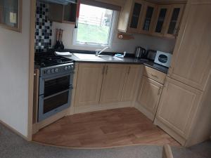 a small kitchen with a stove and a sink at A Hillside Retreat - with garden in Hastings