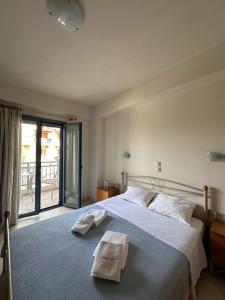 a bedroom with a bed with two towels on it at Green Island Studios in Skala