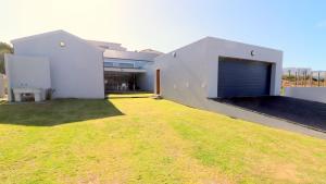 a house with a large yard with a garage at Karen Close 3219 in Struisbaai