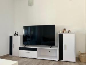 a white entertainment center with a flat screen tv at Apartamento Bermudas in Calpe