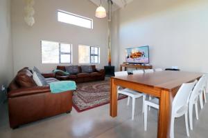 a living room with a table and a couch at Karen Close 3219 in Struisbaai