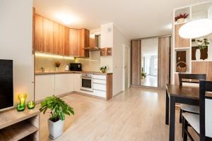 a kitchen and dining room with a dining table at Puck Nowy Świat Comfort Apartments in Puck