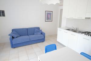 ein Wohnzimmer mit einer blauen Couch in einer Küche in der Unterkunft Marina Village Apartments in Lido di Jesolo