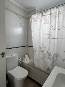 a bathroom with a toilet and a shower curtain at Apartamento Bermudas in Calpe +14 photos
