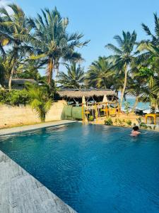 a person in a swimming pool with palm trees at Frangipani Beach Villa in Tangalle
