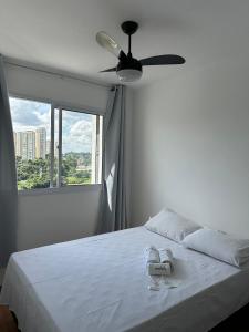 sypialnia z białym łóżkiem i wentylatorem sufitowym w obiekcie TrevizZo Tangara w São Paulo