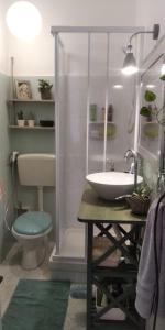 La salle de bains est pourvue d'un lavabo blanc et de toilettes. dans l'établissement Casa Amari alla Zisa HOSTEL, à Palerme