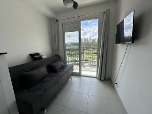 salon z kanapą i dużym oknem w obiekcie TrevizZo Tangara w São Paulo