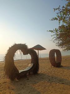 une chaise en foin sur une plage dans l'établissement Chaithalay Khanom Resort, à Ban Phang Phrao
