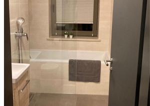 a bathroom with a bath tub and a sink at Stylish and modern - Alm-Flat-Vacation in Oberau +25 photos