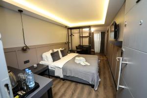 イスタンブールにあるArkem Hotel 2のベッド1台、冷蔵庫が備わる小さな客室です。