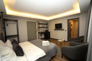 a bedroom with a bed and a chair and a television at Arkem Hotel 2 in Istanbul