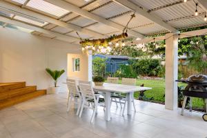 a dining room with a table and chairs and a grill at City Haven - A Slice of Paradise Fringing the CBD in Cairns