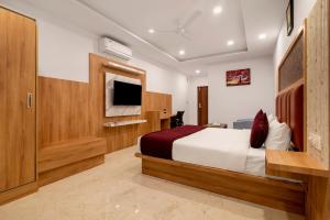 バンガロールにあるGateway Premium Innのベッドとテレビ付きのホテルルーム