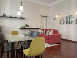 un soggiorno con tavolo da pranzo e divano rosso di Umbria 60 Apartment a Milano