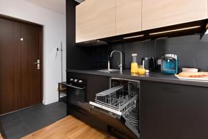 a kitchen with a dishwasher and a sink at Apartament Pomorska in Gdańsk +5 photos