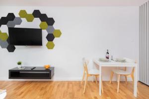 a dining room with a white table and a tv at Apartament Pomorska in Gdańsk