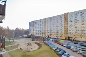 a large building with cars parked in a parking lot at Apartament Pomorska in Gdańsk