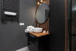 a bathroom with a sink and a mirror at Apartament Pomorska in Gdańsk