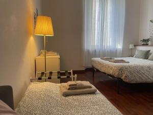 una piccola camera con 2 letti e una lampada di Umbria 60 Apartment a Milano